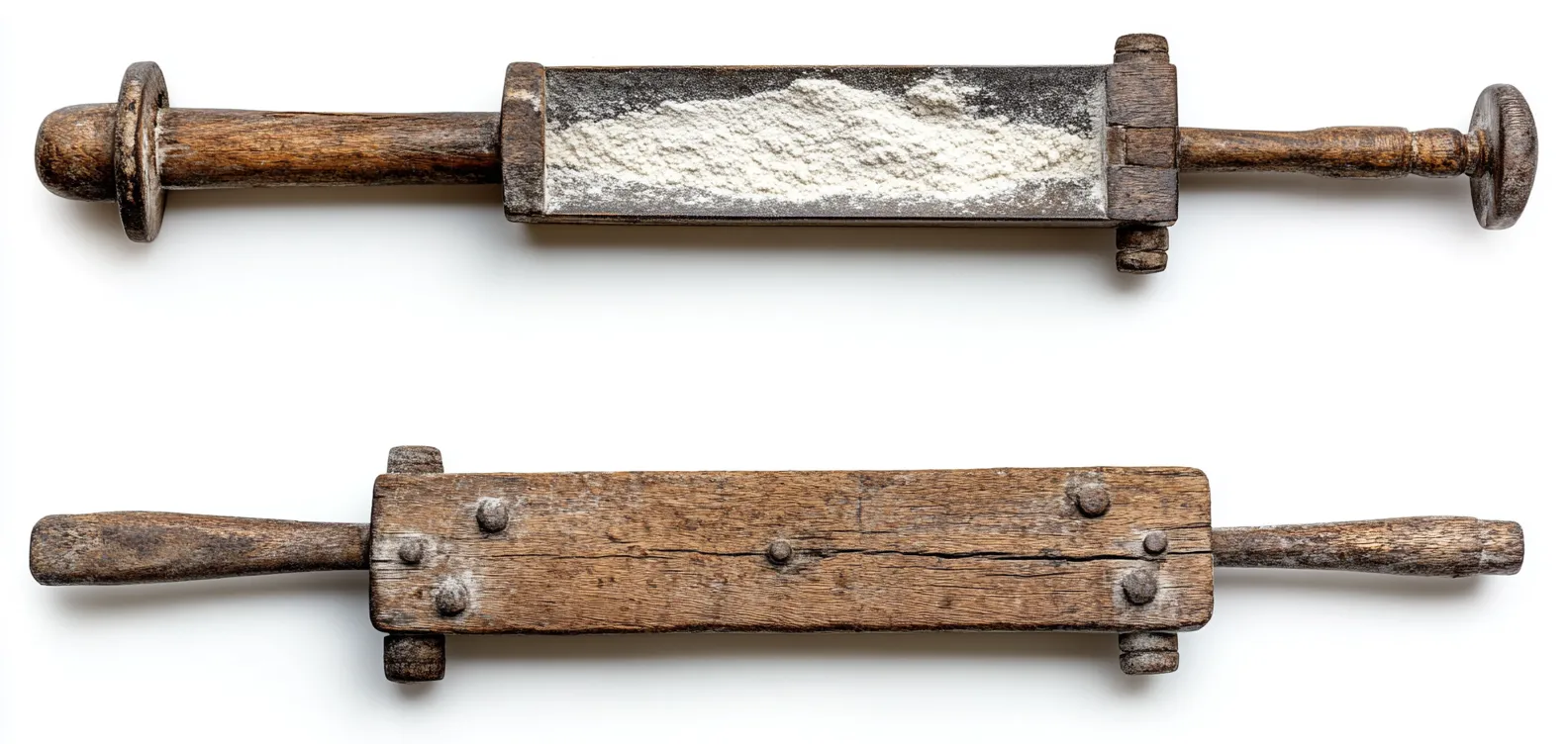 Two antique wooden milling tools with a handle at each end, one a narrow trough filled with flour and the other a flat board studded with iron rivets